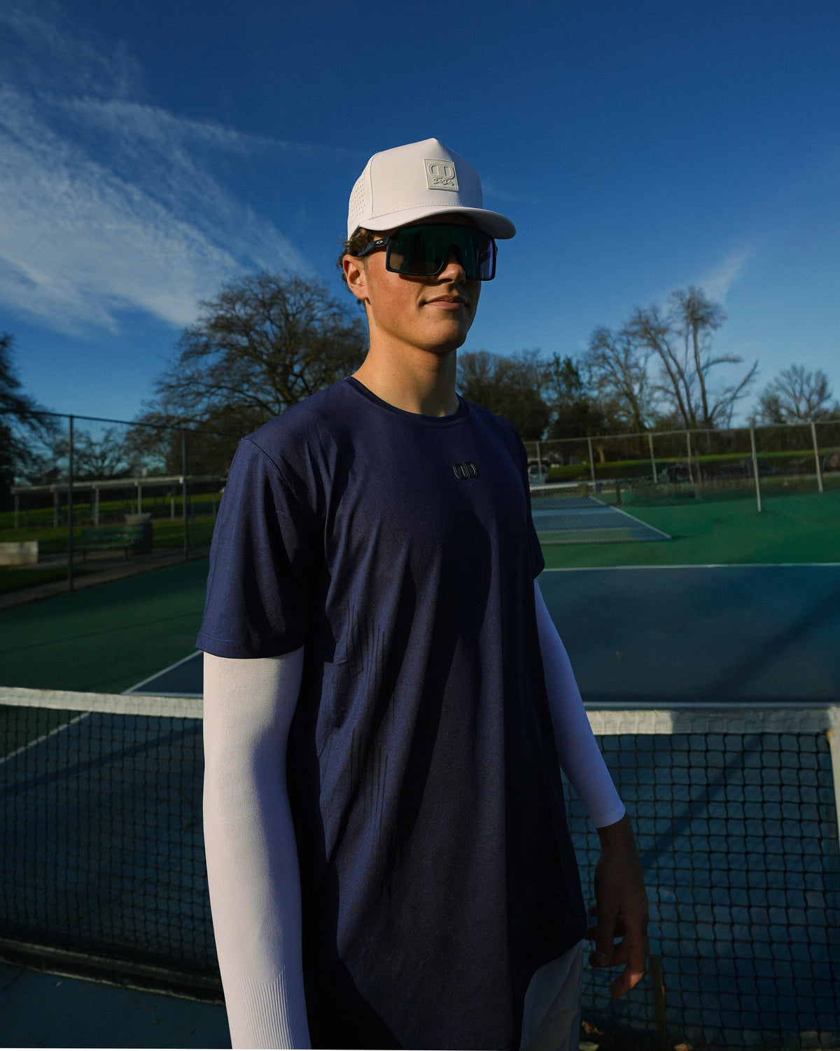 man wearing white hat and blue athletic shirt outdoors